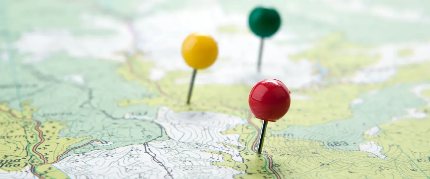 Map with a red, a yellow, and a green pin.
