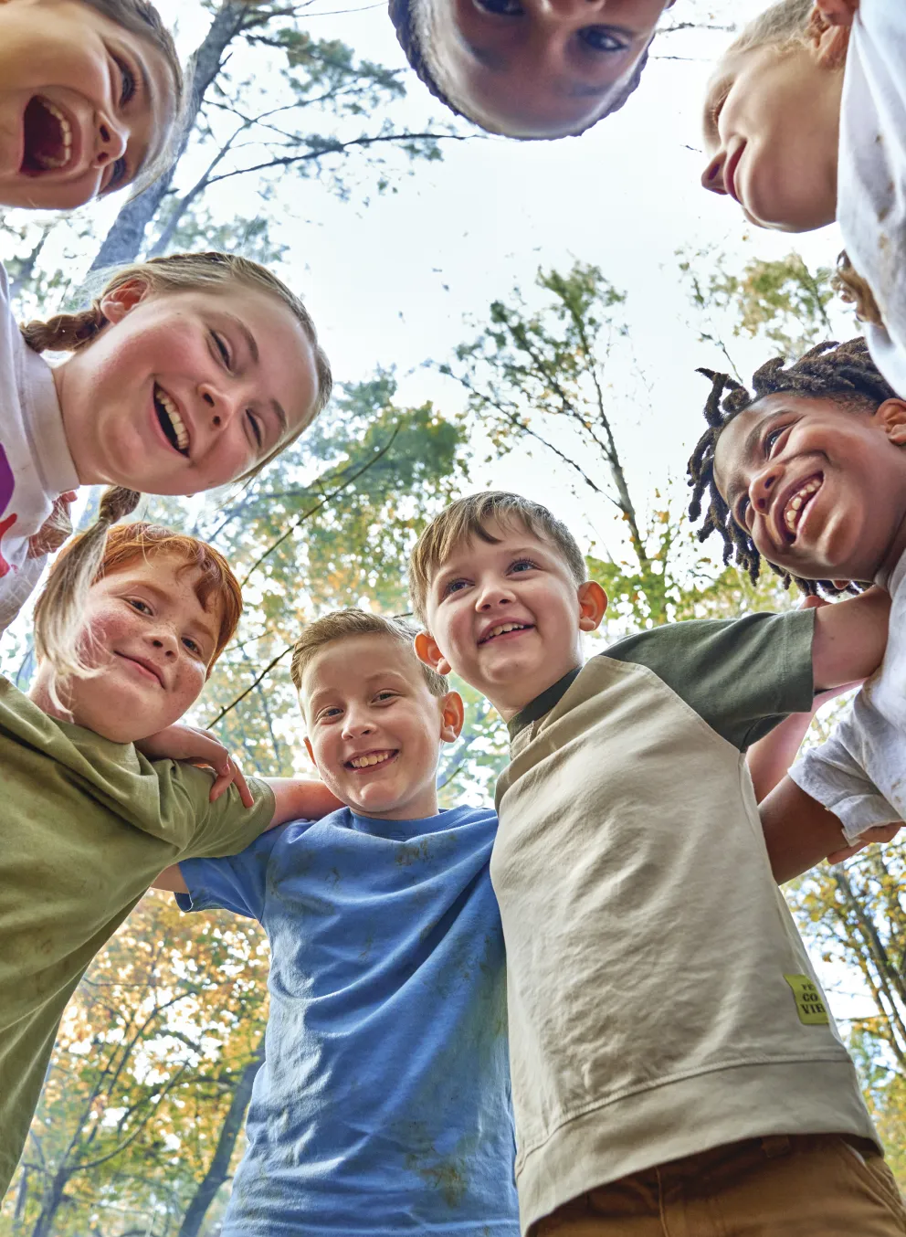 Kids laughing in a huddle outside