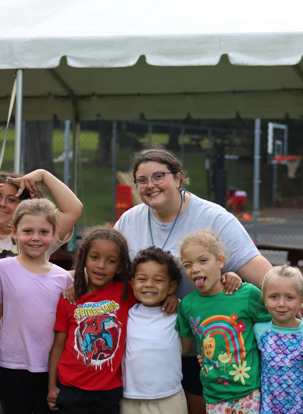 Female counselor standing with 9 campers