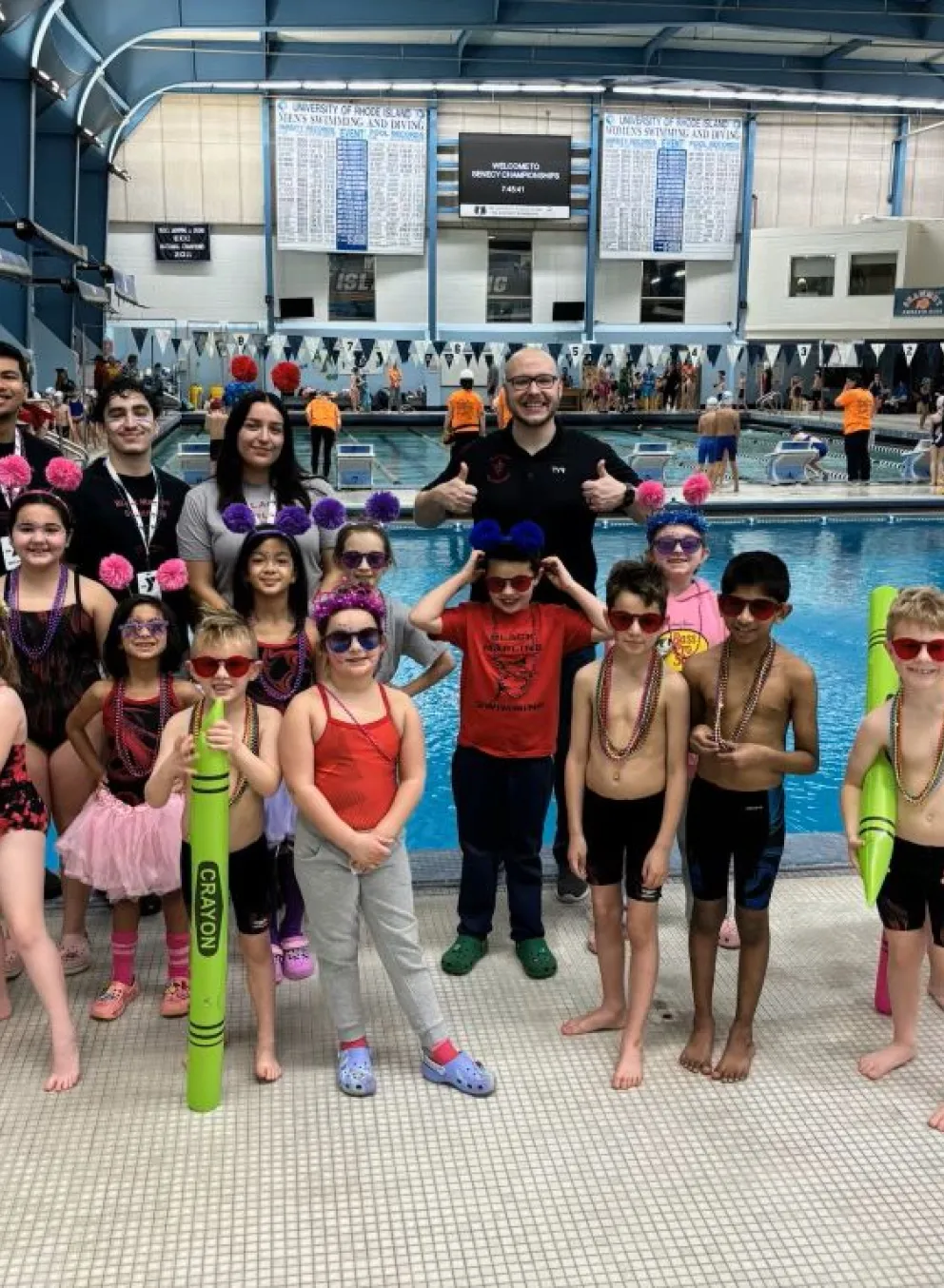 Swim Team posing with coaches at Swim Meet