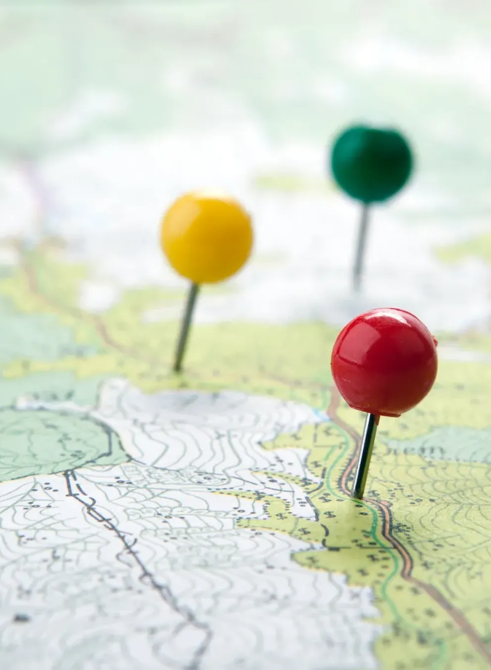 Map with a red, a yellow, and a green pin.