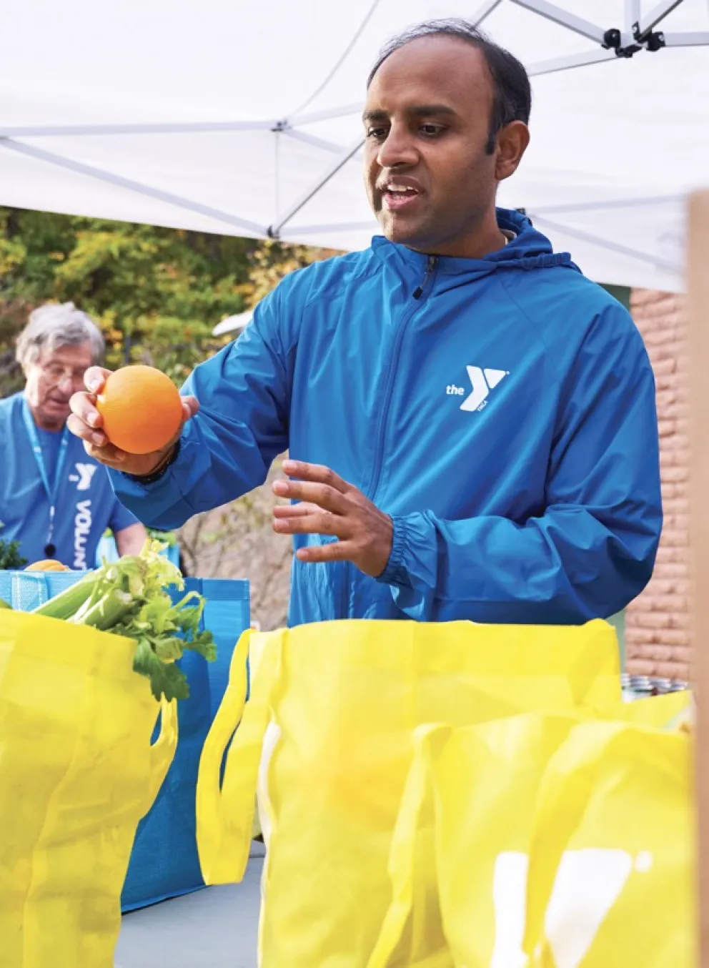 Male volunteer placing fruit in bags