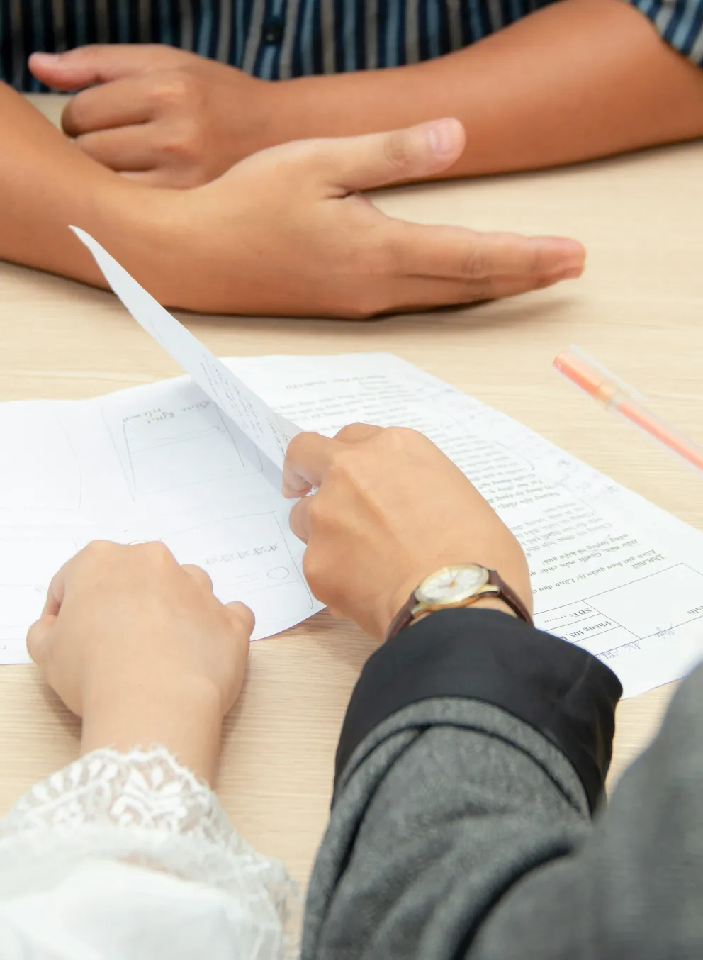 Three people sitting at a table with papers.