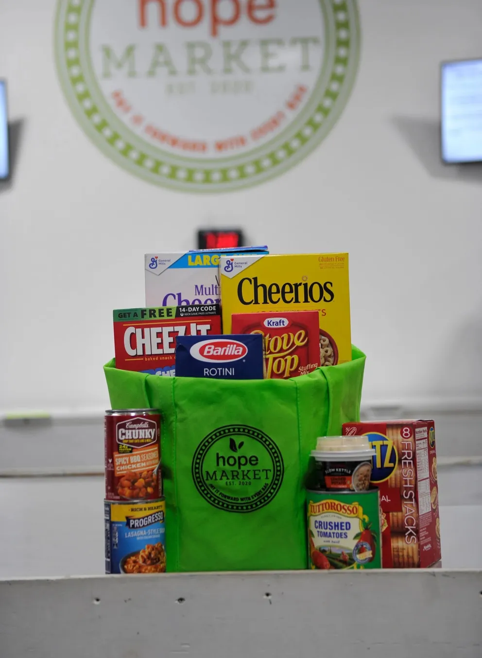 Green bag that says "Hope Market" with various non-perishable items in it.