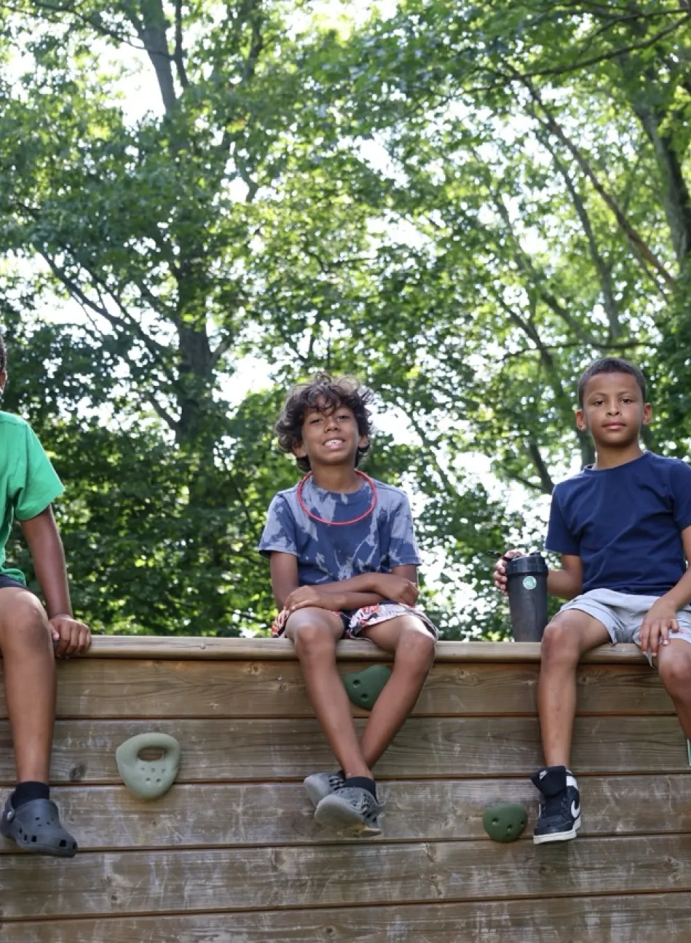 Three boys sitting on a wall