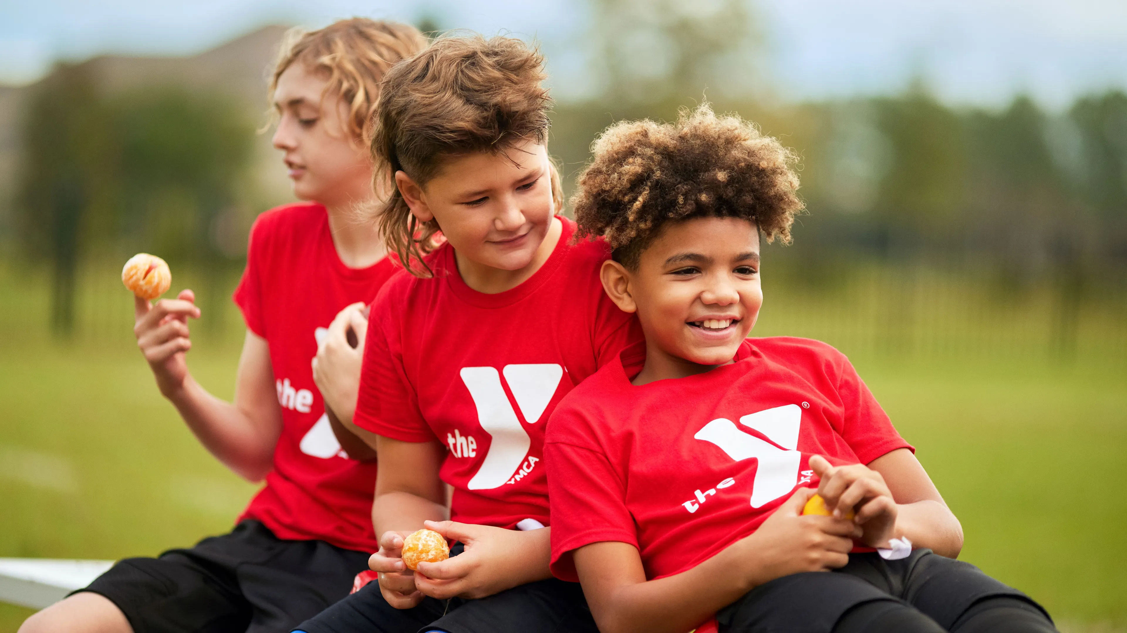 Three boys sitting on bench