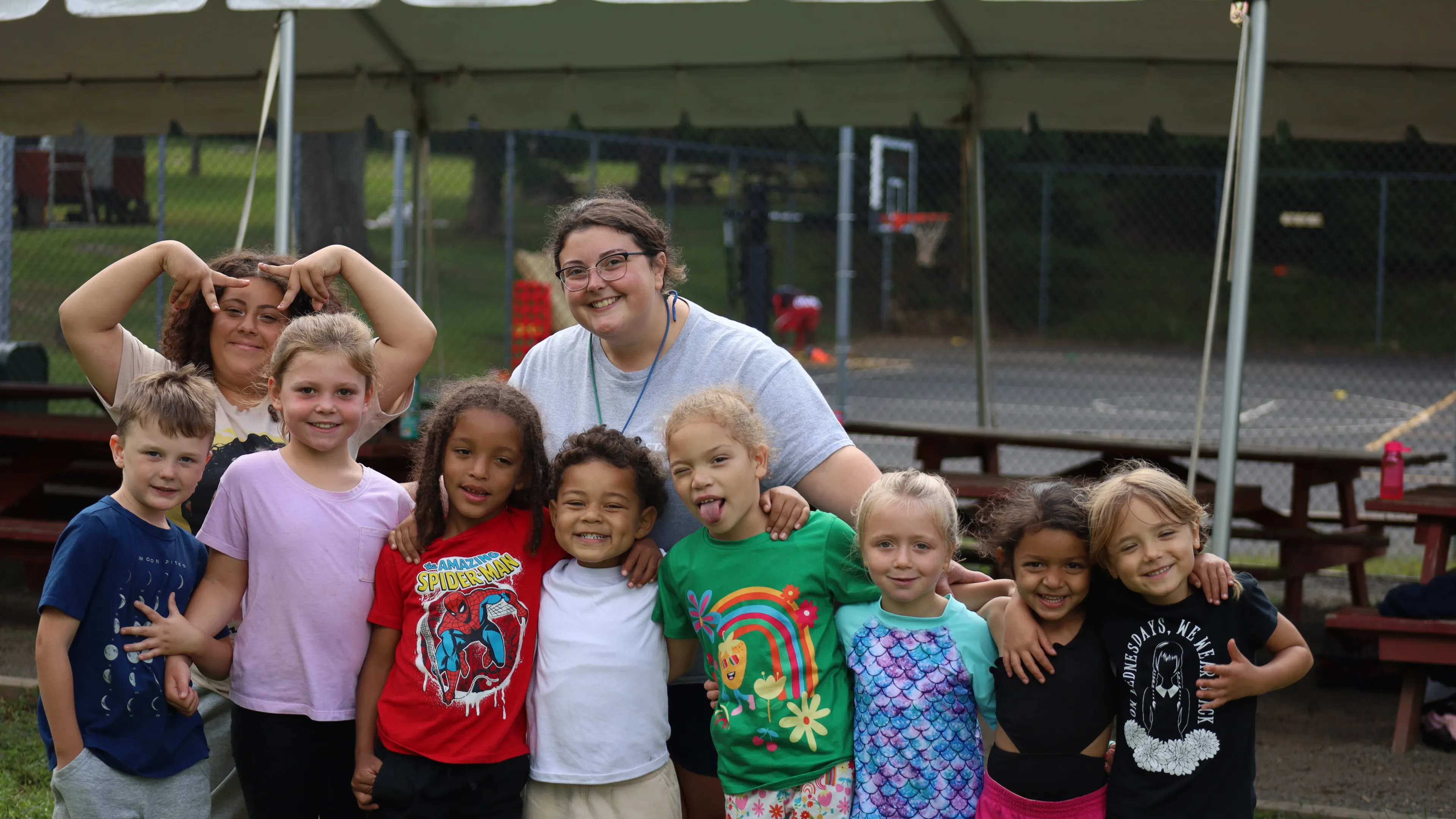 Female counselor standing with 9 campers
