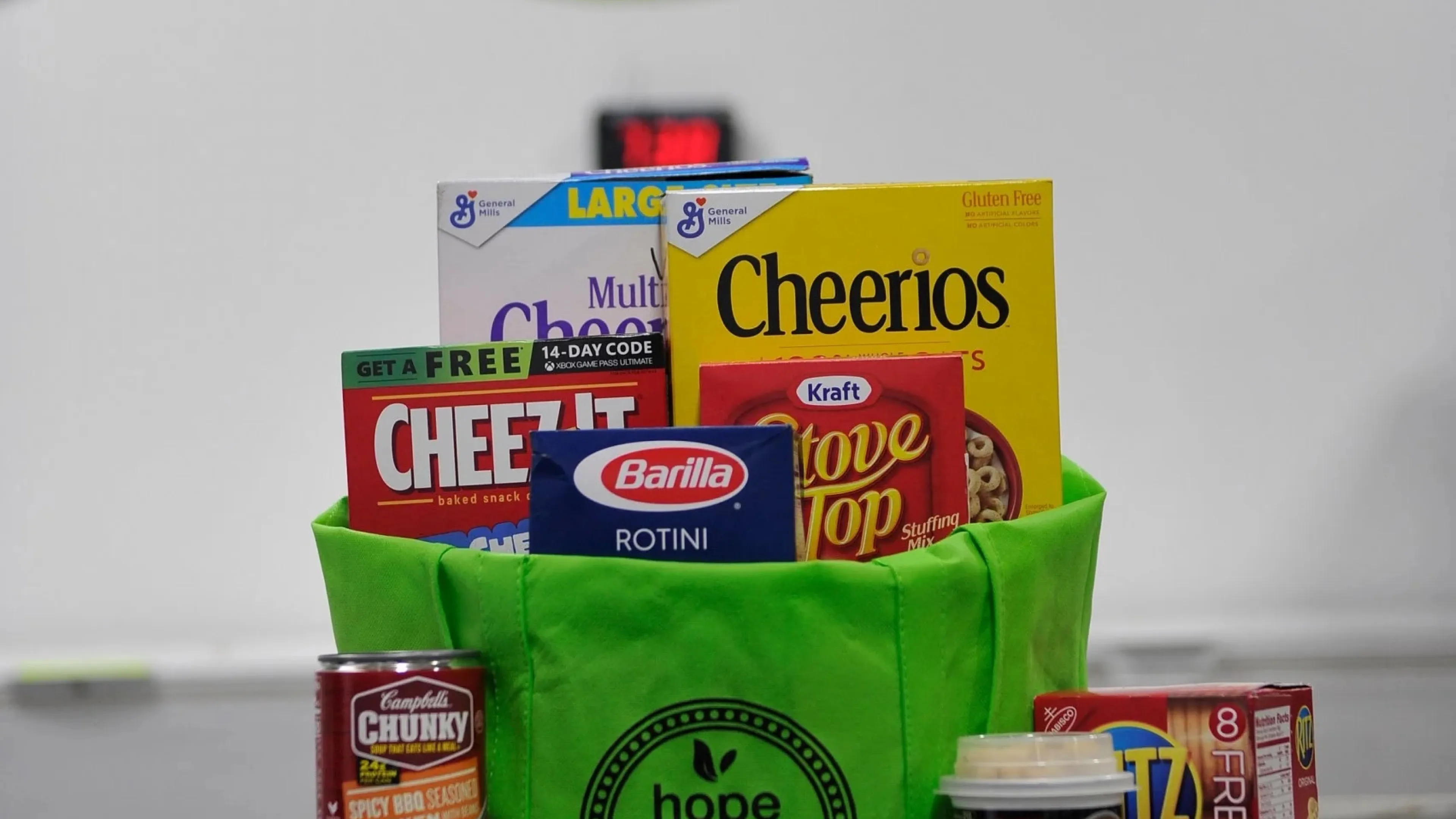 Green bag that says "Hope Market" with various non-perishable items in it.