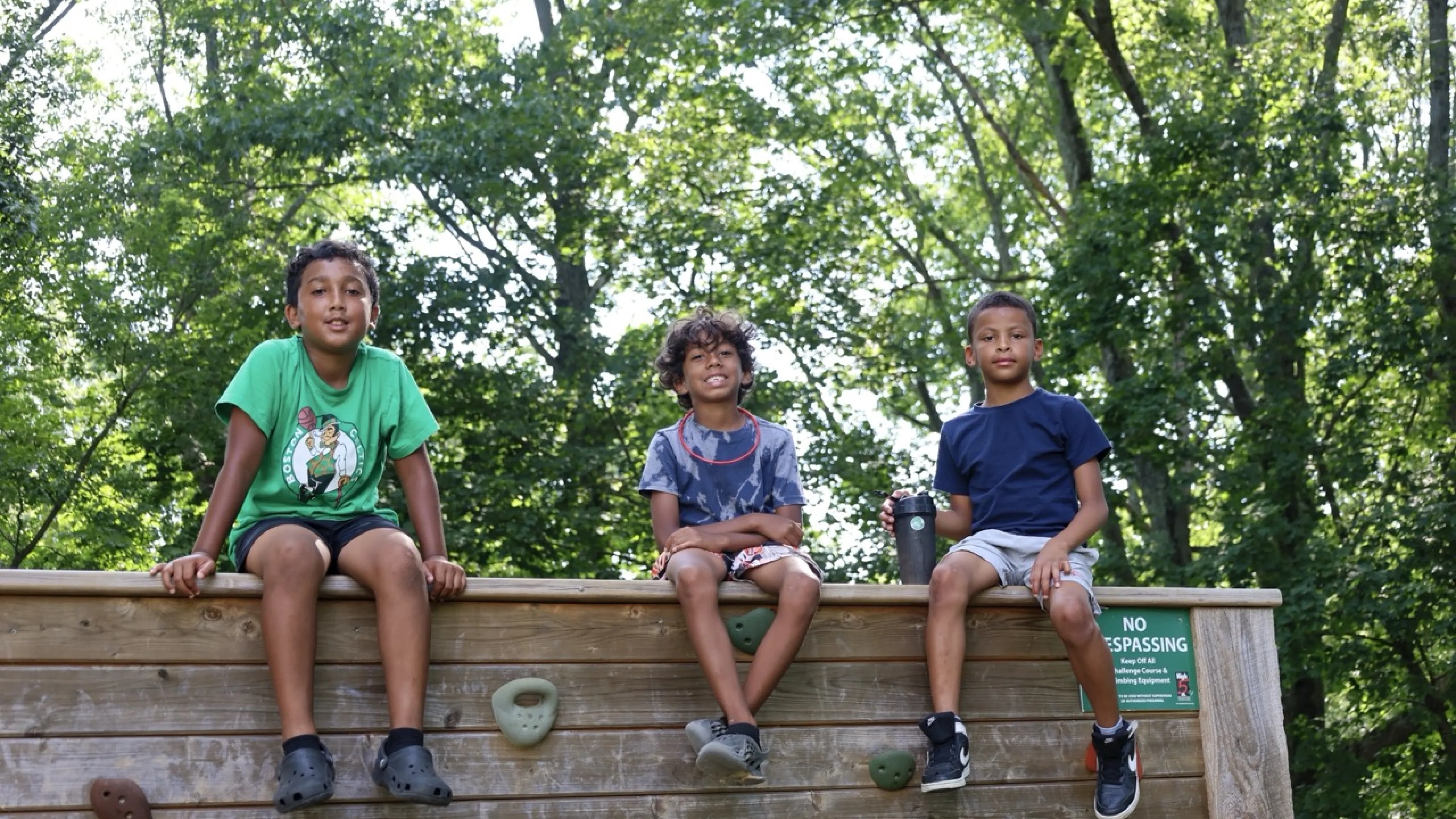 Three boys sitting on a wall