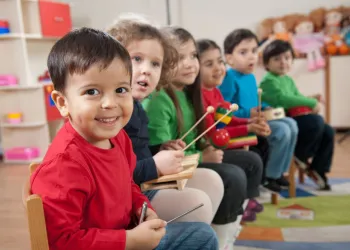 Young kids playing a variety of different musical instruments