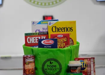 Green bag that says "Hope Market" with various non-perishable items in it.