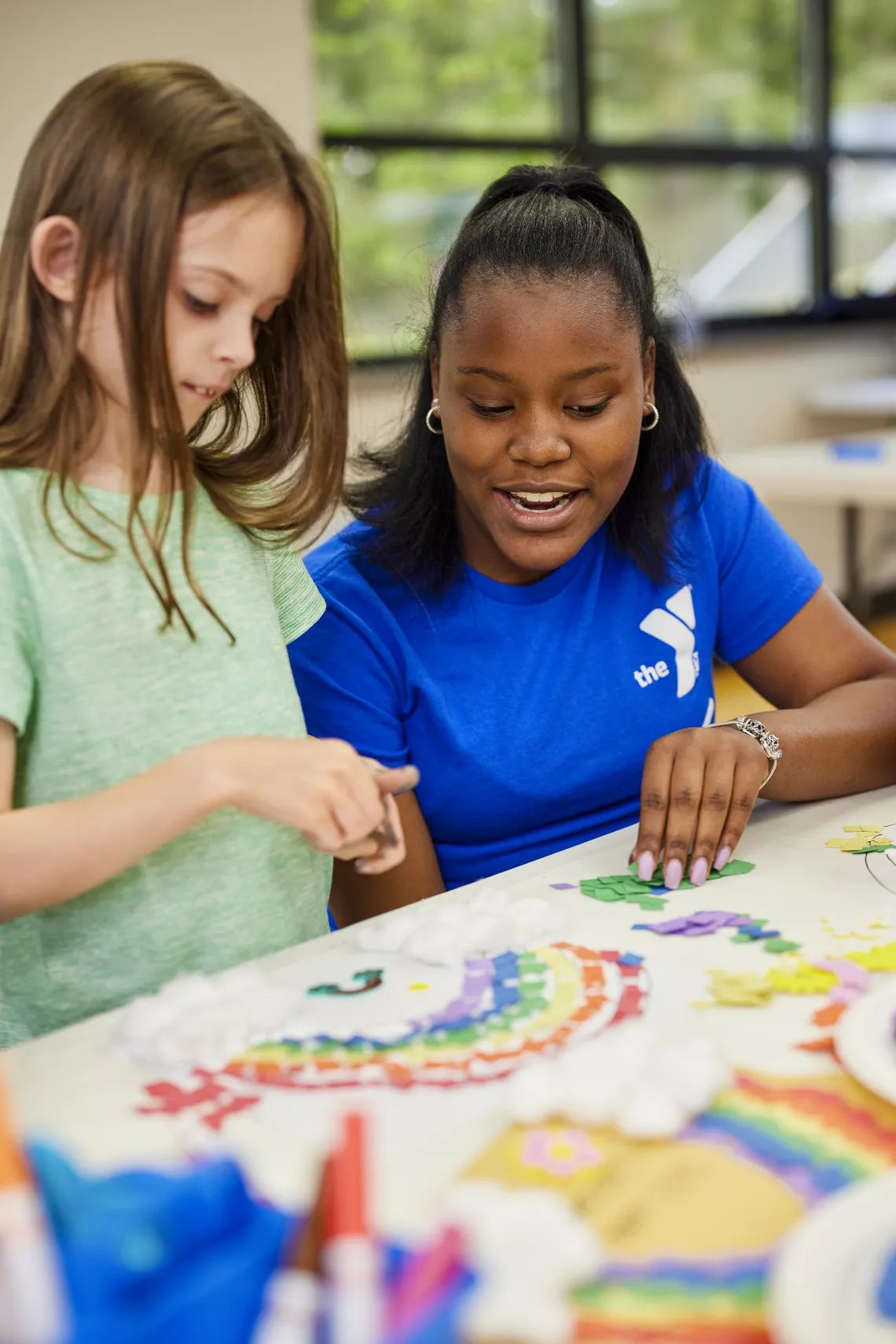 Female staff doing an art project with a girl