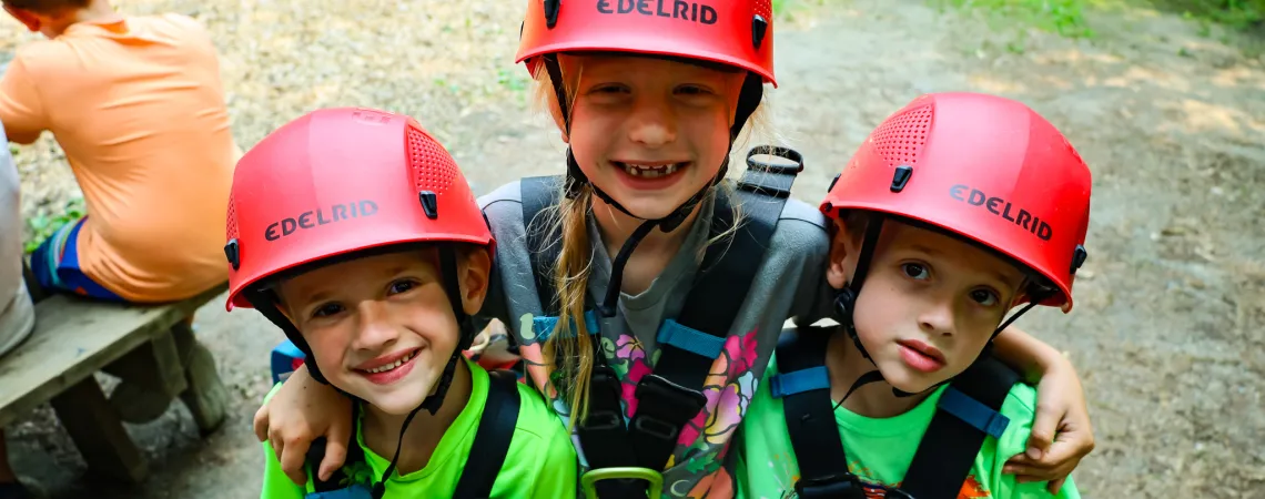 Three Kids SMiling at Summer Camp in Rock Climbing Gear