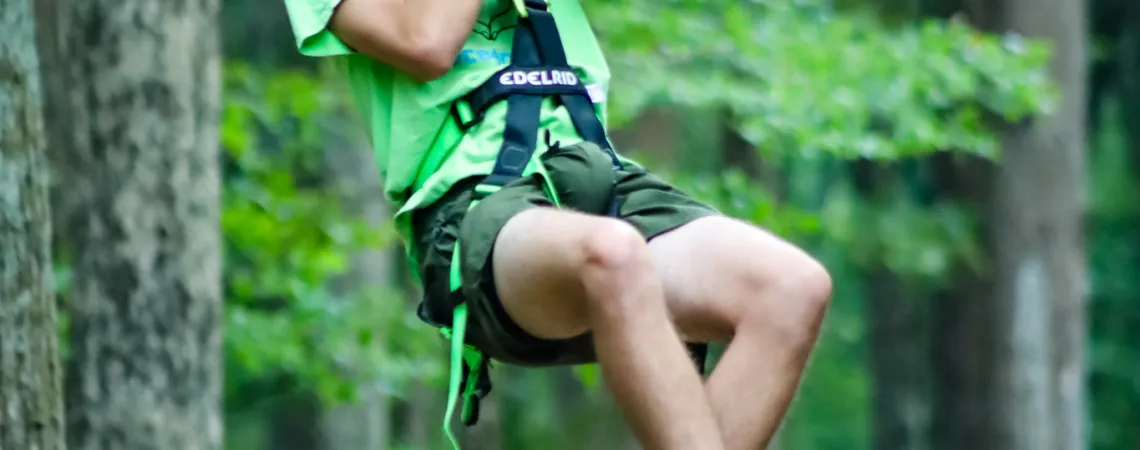 Man Smiling on A Zipline at a Summer Camp